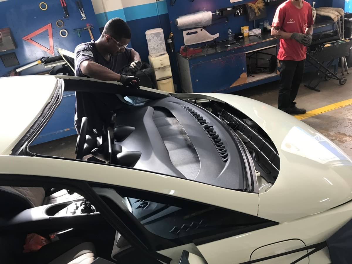 Técnico da Furlan Auto Vidros instalando para-brisa em carro no box da loja em Ribeirão Preto